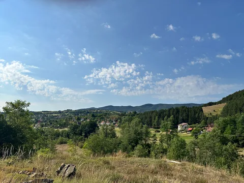 Panorama Kremana sa domaćinstvima, livadama i šumovitim padinama.